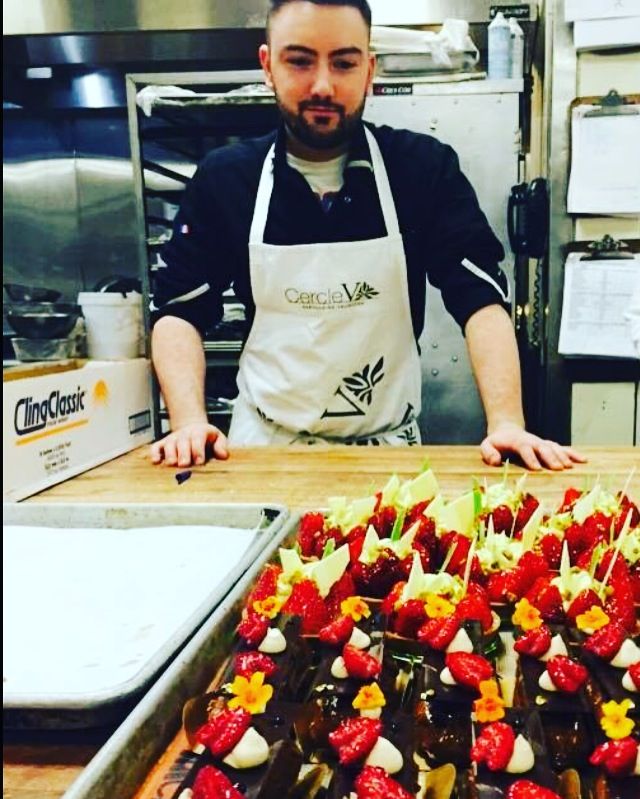 Florian Bazin en cuisine devant un plateau de desserts